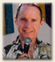 A photograph of Allan Hardman with a microphone, inviting you to click and listen