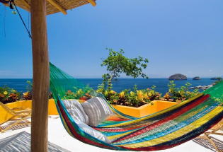 Relax in hammock looking out over bay and Los Arcos Islands.